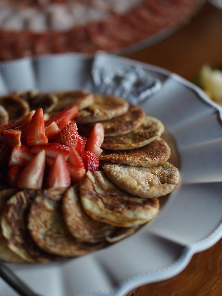 Travessa de panquecas com morangos frescos, servida no brunch