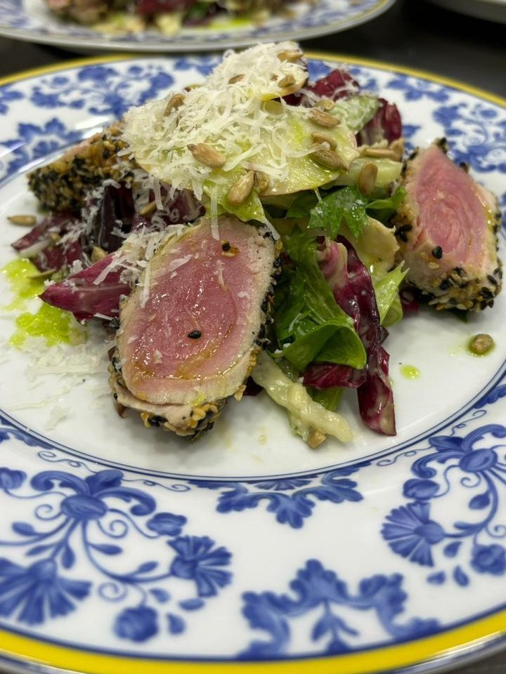 Prato empratado: carne selada em crosta de gergelim sobre salada, em louça azul e branca
